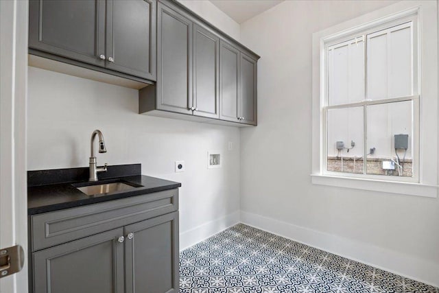 laundry area with cabinet space, baseboards, hookup for a washing machine, hookup for an electric dryer, and a sink