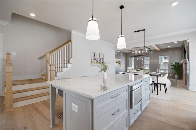 kitchen featuring recessed lighting, light wood-type flooring, a kitchen island, and pendant lighting