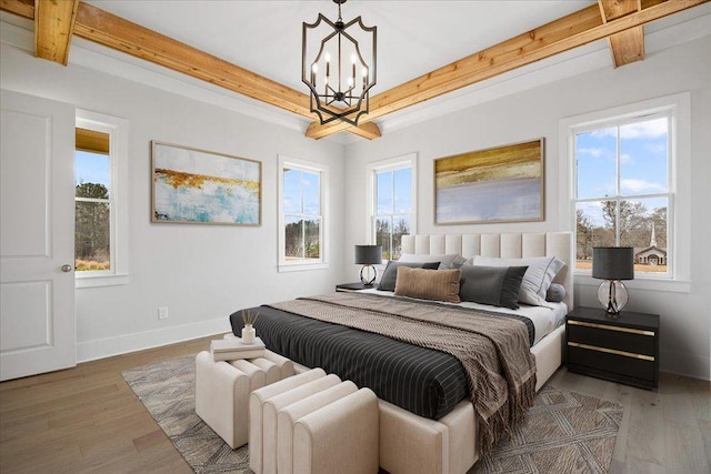 bedroom with light wood-type flooring, multiple windows, and beam ceiling