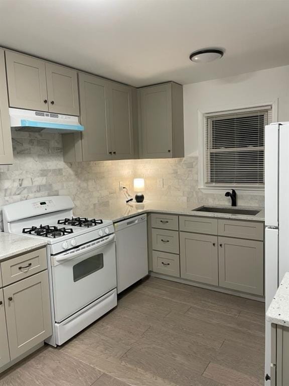 2225 Harold Ln SE, Smyrna, GA 30080 - kitchen featuring white appliances, under cabinet range hood, a sink, gray cabinets, and backsplash