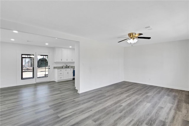 unfurnished living room featuring recessed lighting, wood finished floors, visible vents, and baseboards