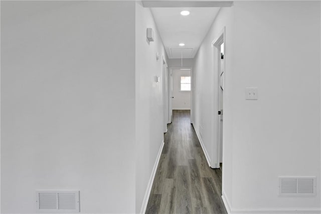 hallway with visible vents, baseboards, and attic access