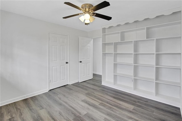 unfurnished bedroom featuring wood finished floors, baseboards, and ceiling fan