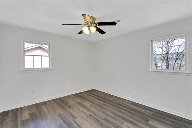 unfurnished room featuring a ceiling fan, dark wood-type flooring, and baseboards