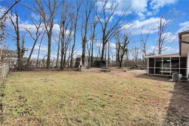 view of yard with central AC and a sunroom