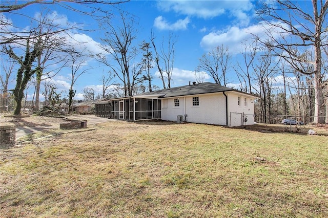 rear view of property featuring a yard and a sunroom