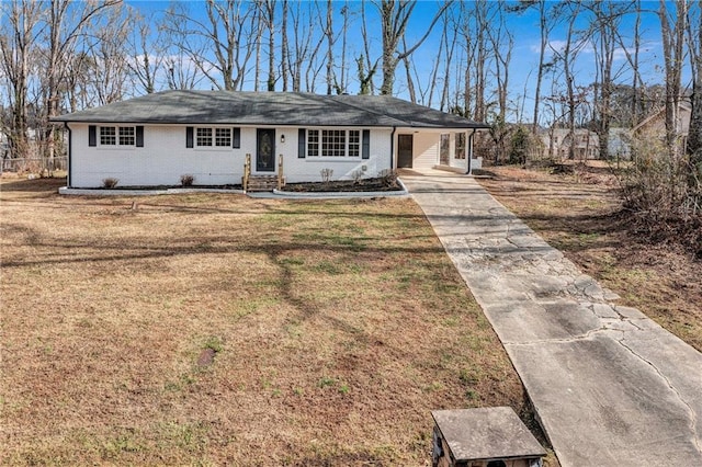 single story home featuring brick siding and a front yard