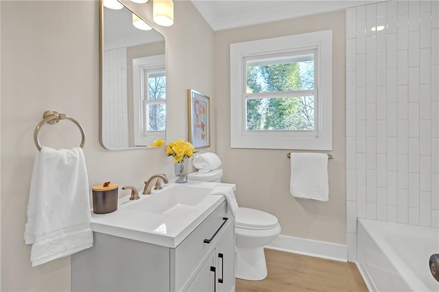 bathroom with toilet, vanity, plenty of natural light, and hardwood / wood-style floors