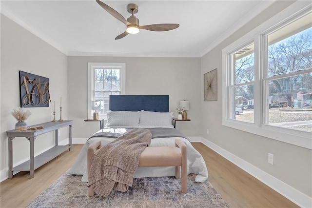 bedroom featuring ceiling fan, wood-type flooring, and ornamental molding