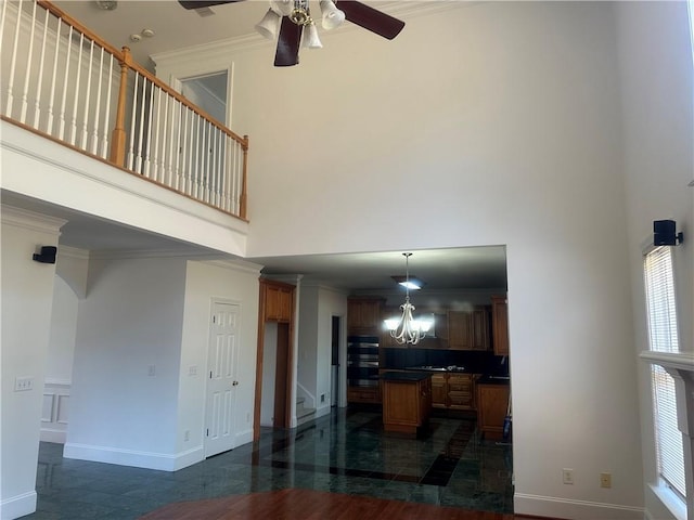 living room featuring ornamental molding, a towering ceiling, baseboards, arched walkways, and a ceiling fan
