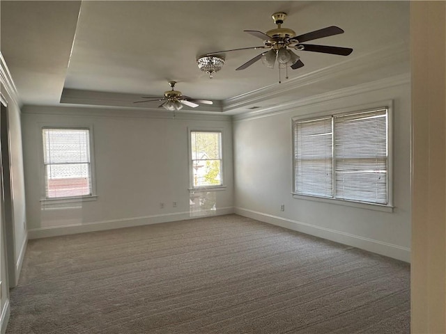 carpeted empty room featuring baseboards, ornamental molding, a raised ceiling, and ceiling fan