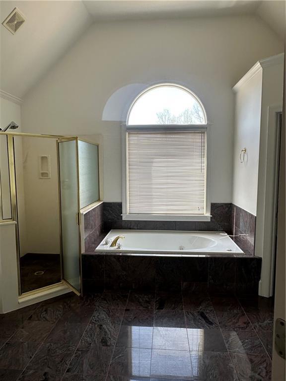 bathroom with a bath, visible vents, a shower stall, and lofted ceiling