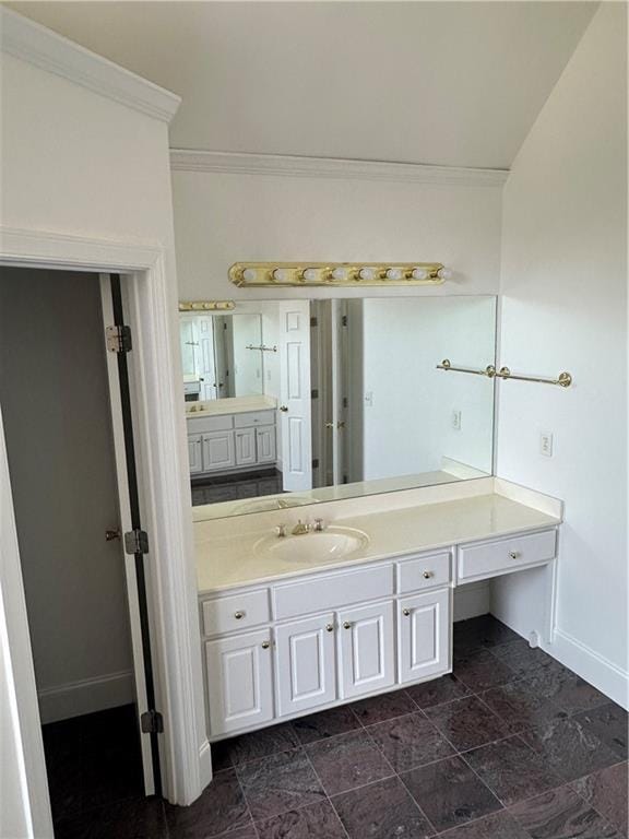 bathroom with crown molding, baseboards, and vanity