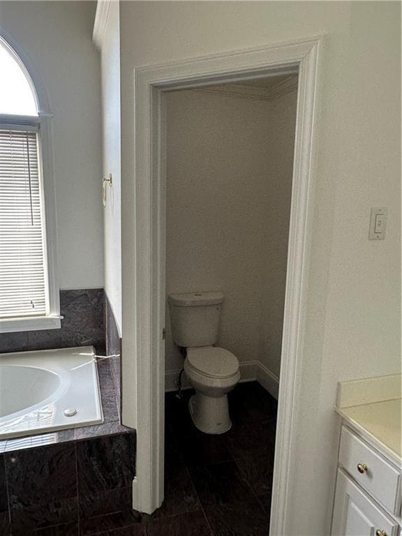 bathroom with a garden tub, tile patterned floors, toilet, and vanity