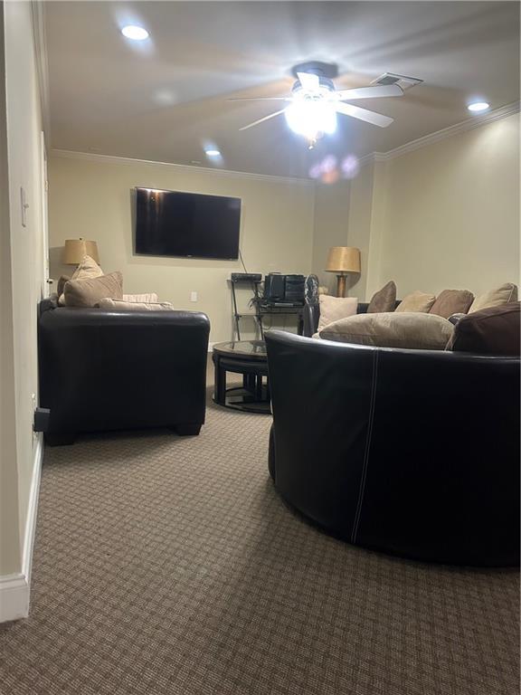 carpeted living area with a ceiling fan, recessed lighting, ornamental molding, and visible vents