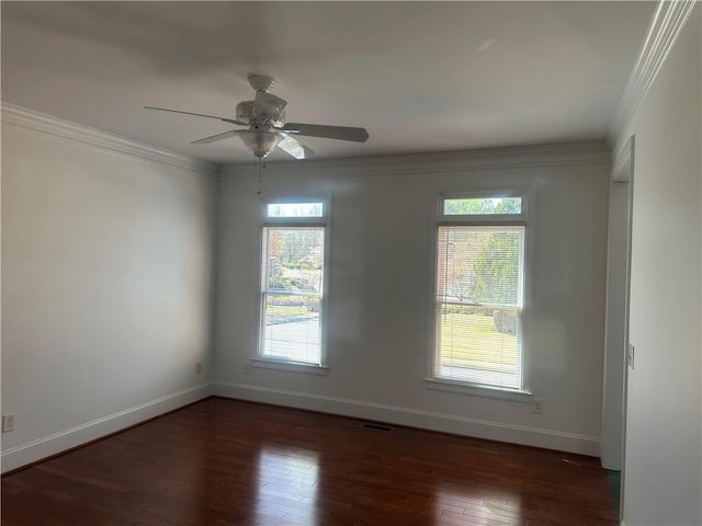 spare room with wood-type flooring, baseboards, visible vents, and a wealth of natural light