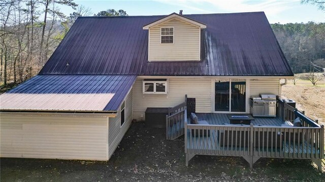 back of property with metal roof and a deck