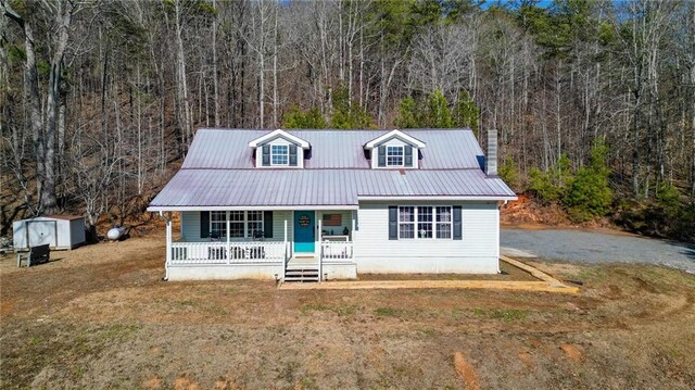 view of exterior entry featuring metal roof and covered porch