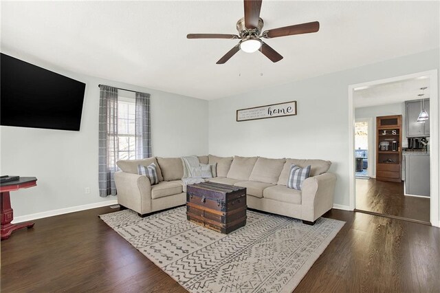 living area with wood finished floors, baseboards, and ceiling fan