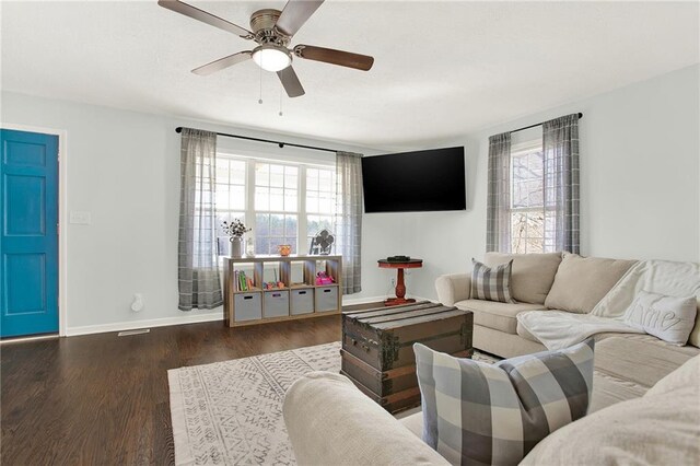 living room featuring ceiling fan, baseboards, and wood finished floors