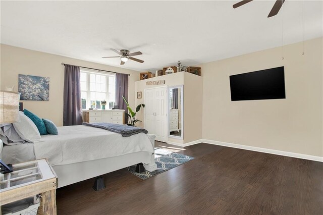 bedroom with a ceiling fan, baseboards, and dark wood-style flooring