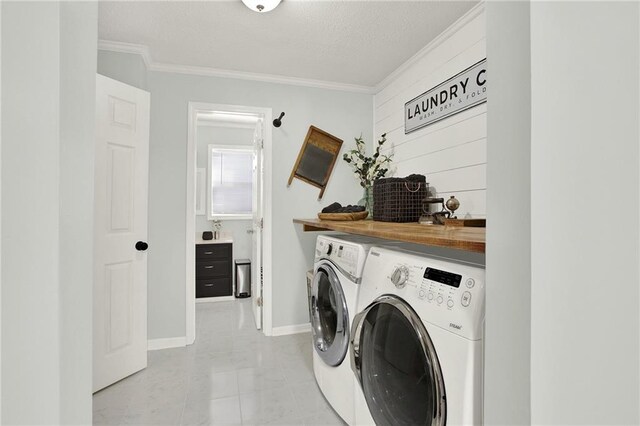 clothes washing area with laundry area, ornamental molding, baseboards, and washing machine and clothes dryer