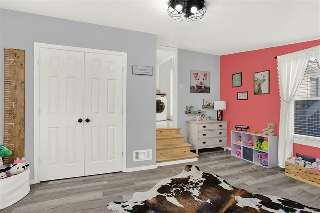 game room featuring visible vents, washer / clothes dryer, and wood finished floors