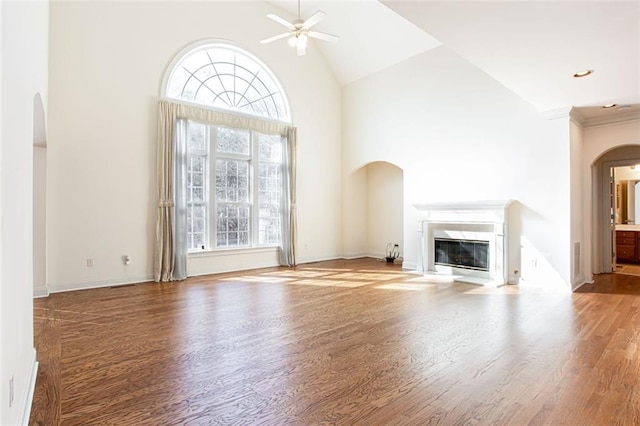 unfurnished living room with hardwood / wood-style floors, high vaulted ceiling, and ceiling fan