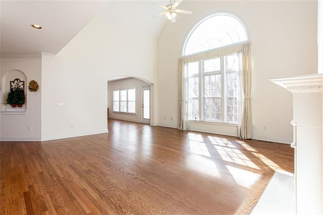 unfurnished living room featuring wood-type flooring, ceiling fan, and high vaulted ceiling