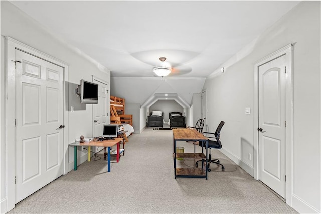 carpeted home office featuring lofted ceiling