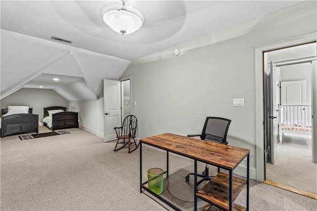 carpeted home office featuring vaulted ceiling