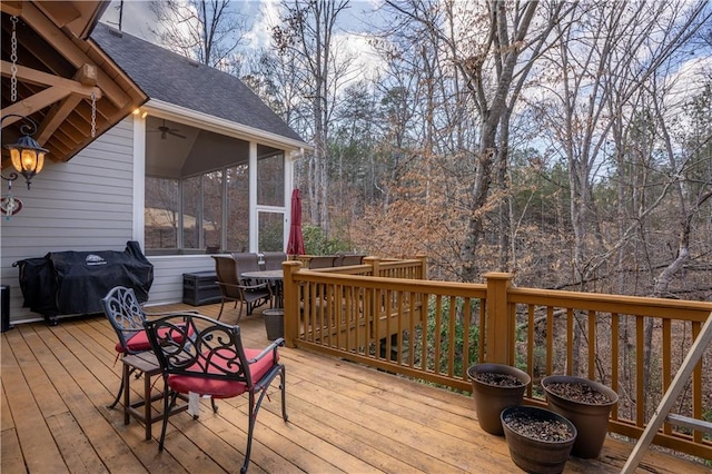 wooden terrace with a grill, a sunroom, and ceiling fan