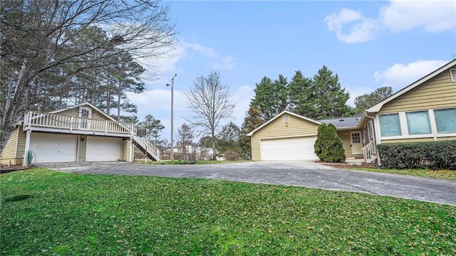 exterior space with a garage, stairs, and aphalt driveway