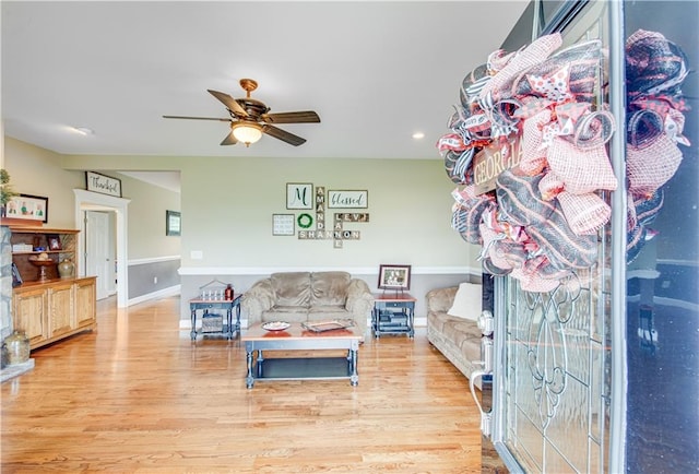 living room with ceiling fan and light hardwood / wood-style flooring