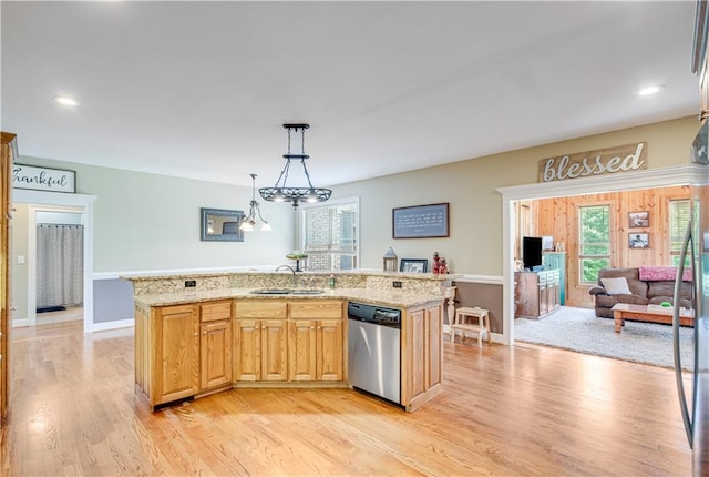 kitchen featuring decorative light fixtures, a kitchen island with sink, sink, light hardwood / wood-style flooring, and dishwasher