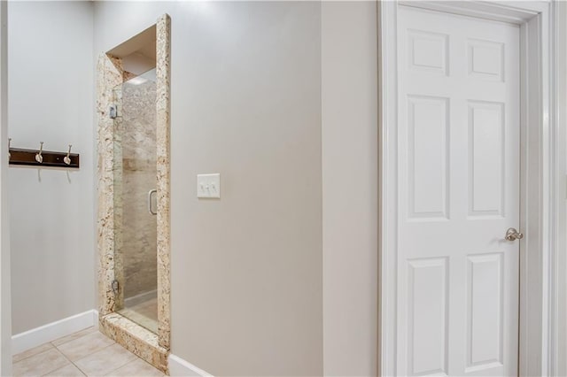 bathroom with tile flooring and a shower with shower door