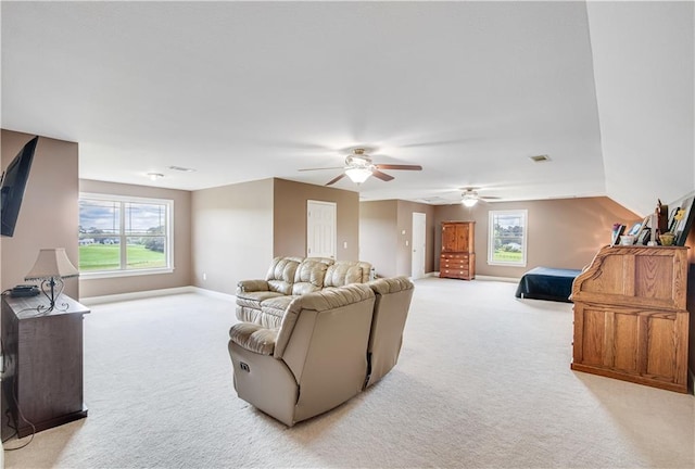 living room with plenty of natural light, ceiling fan, and light carpet