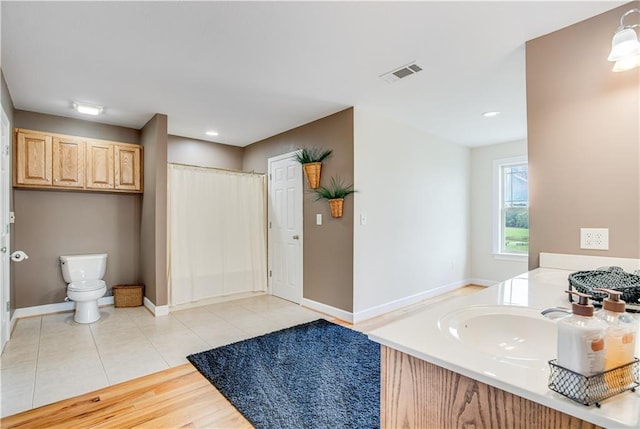 bathroom featuring tile floors, toilet, and vanity