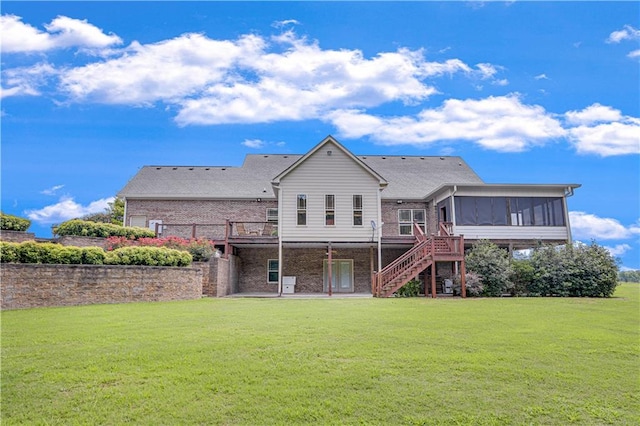 back of property featuring a sunroom and a lawn