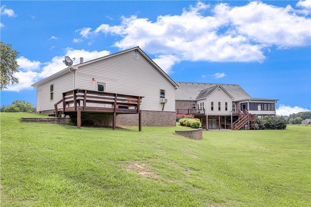 back of house featuring a wooden deck and a lawn