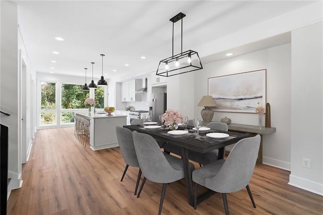 dining space featuring recessed lighting, baseboards, and light wood-style flooring