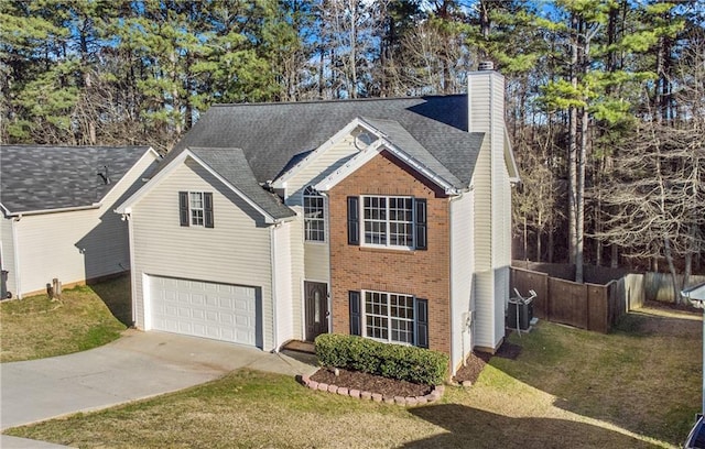 traditional home featuring concrete driveway, a chimney, an attached garage, and a front yard