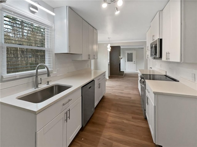 kitchen featuring hanging light fixtures, white cabinetry, appliances with stainless steel finishes, and sink