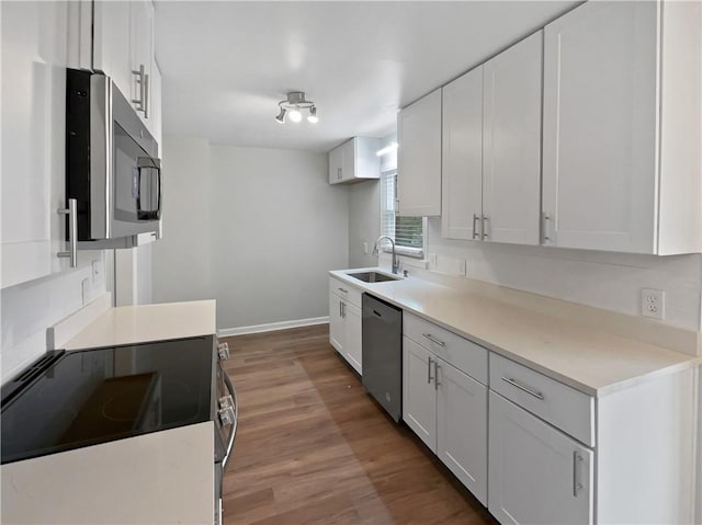 kitchen with white cabinetry, sink, dark hardwood / wood-style flooring, and appliances with stainless steel finishes