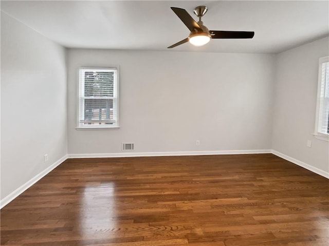 spare room featuring dark wood-type flooring and ceiling fan