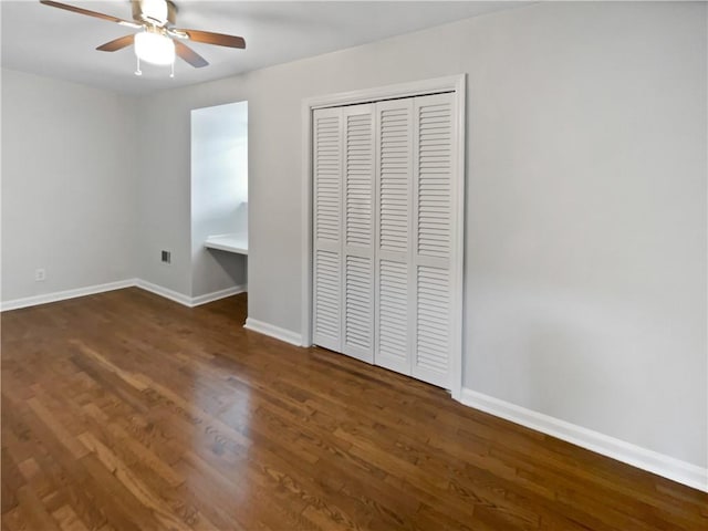 unfurnished bedroom featuring ceiling fan, dark hardwood / wood-style floors, and a closet