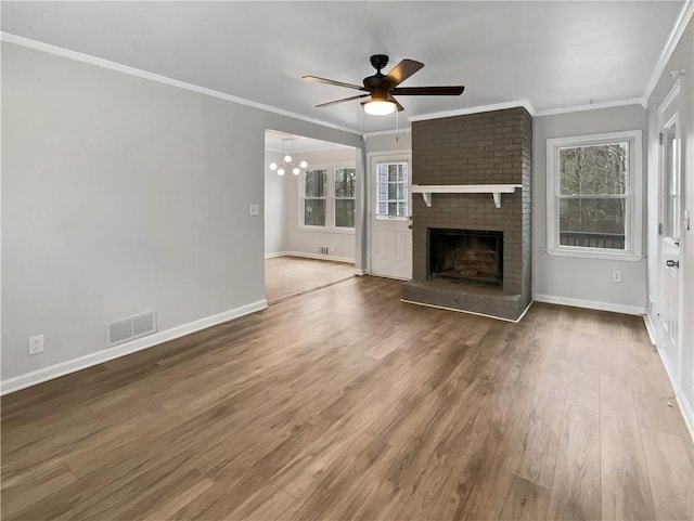 unfurnished living room with crown molding, wood-type flooring, ceiling fan, and a healthy amount of sunlight