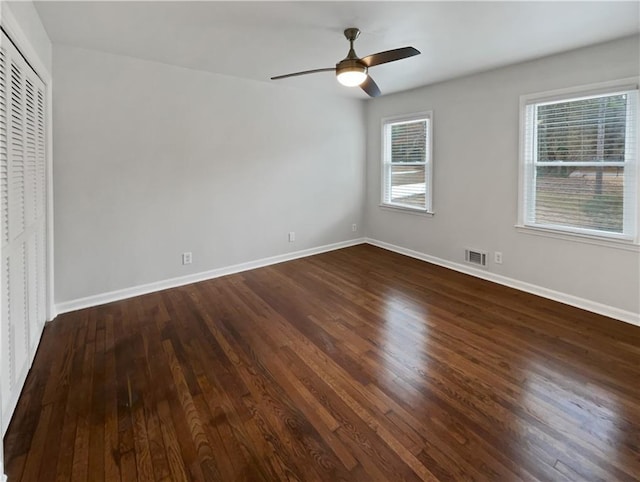 empty room with dark wood-type flooring and ceiling fan