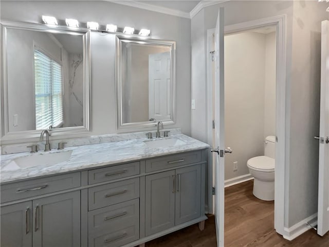 bathroom featuring hardwood / wood-style flooring, vanity, ornamental molding, and toilet