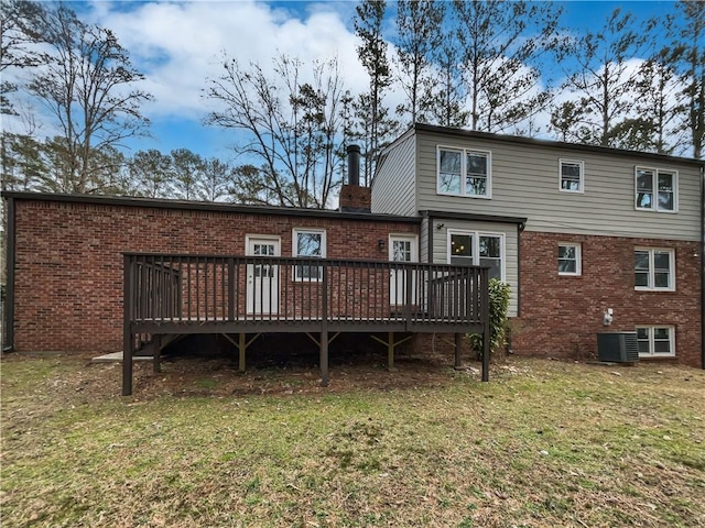 rear view of property with a yard, a deck, and central air condition unit